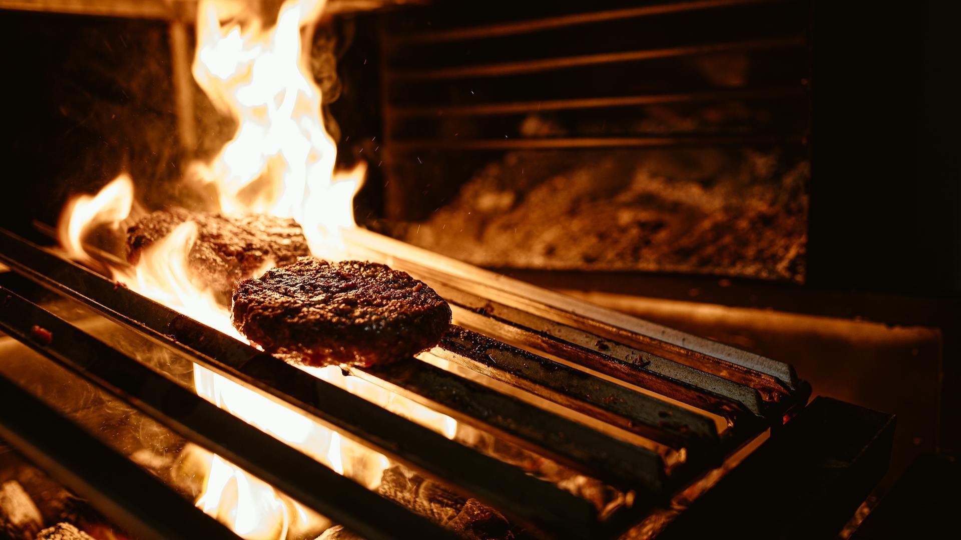 Smash burger being pressed on a flat-top grill